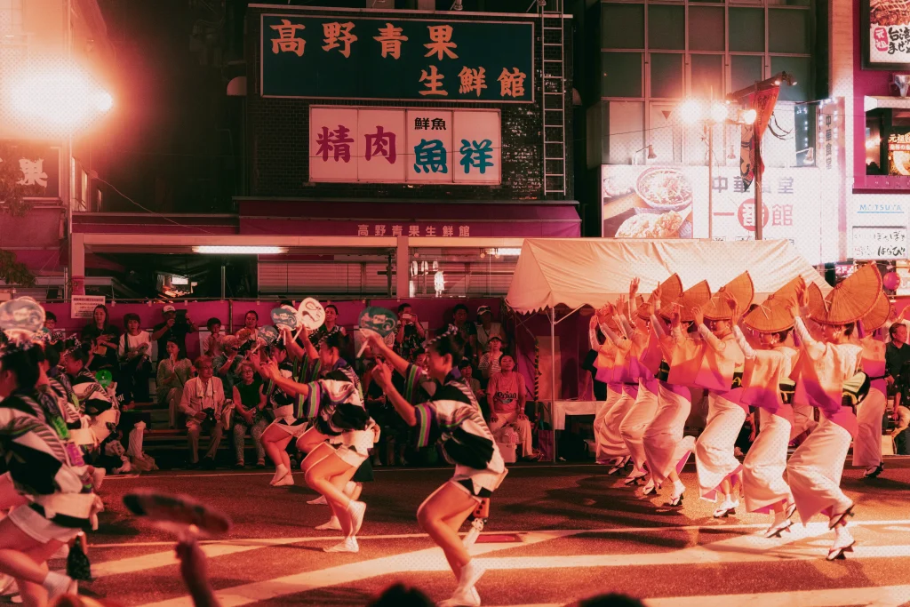 image du festival dansant d'Awa Odori dans une rue éclairée de nuit à Tokushima